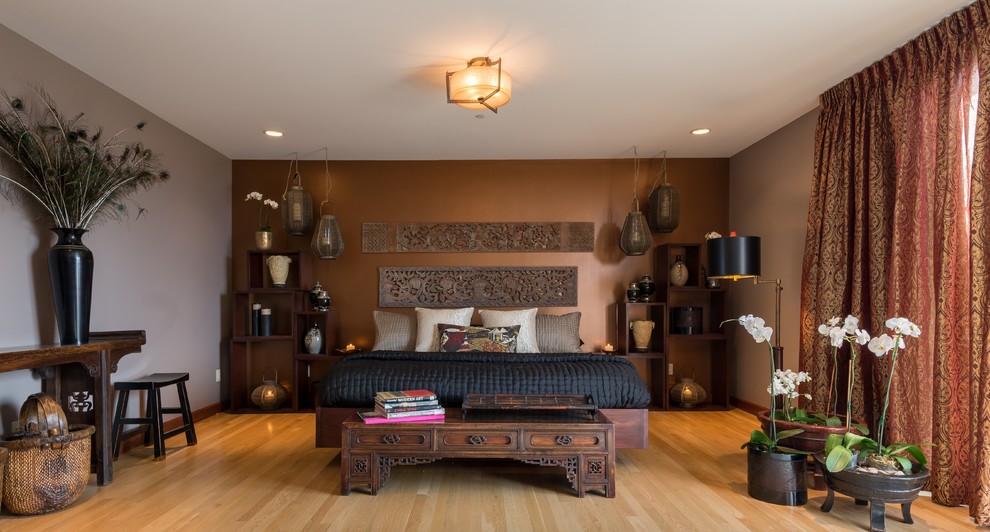 Design ideas for a large asian master bedroom in Albuquerque with brown walls and light hardwood floors.