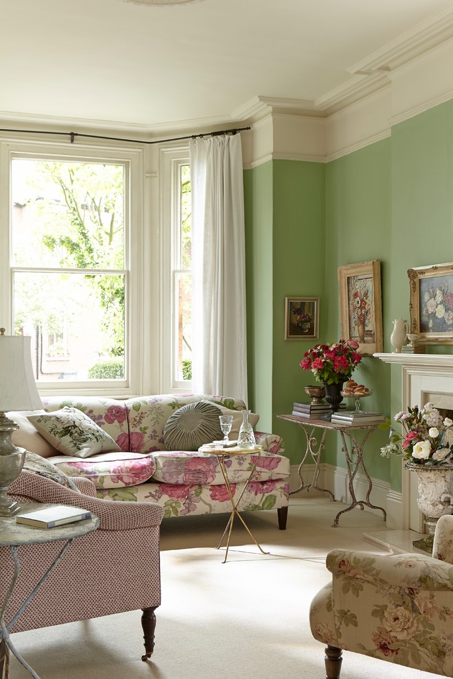 Photo of a country living room in London with green walls, carpet and beige floor.