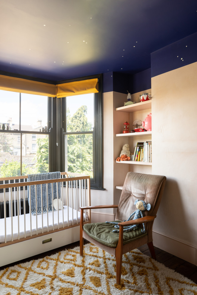 Inspiration for an eclectic nursery in London with beige walls, dark hardwood floors and brown floor.