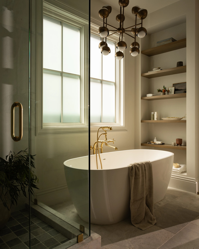 Example of a transitional gray floor freestanding bathtub design in Los Angeles with beige walls and a hinged shower door