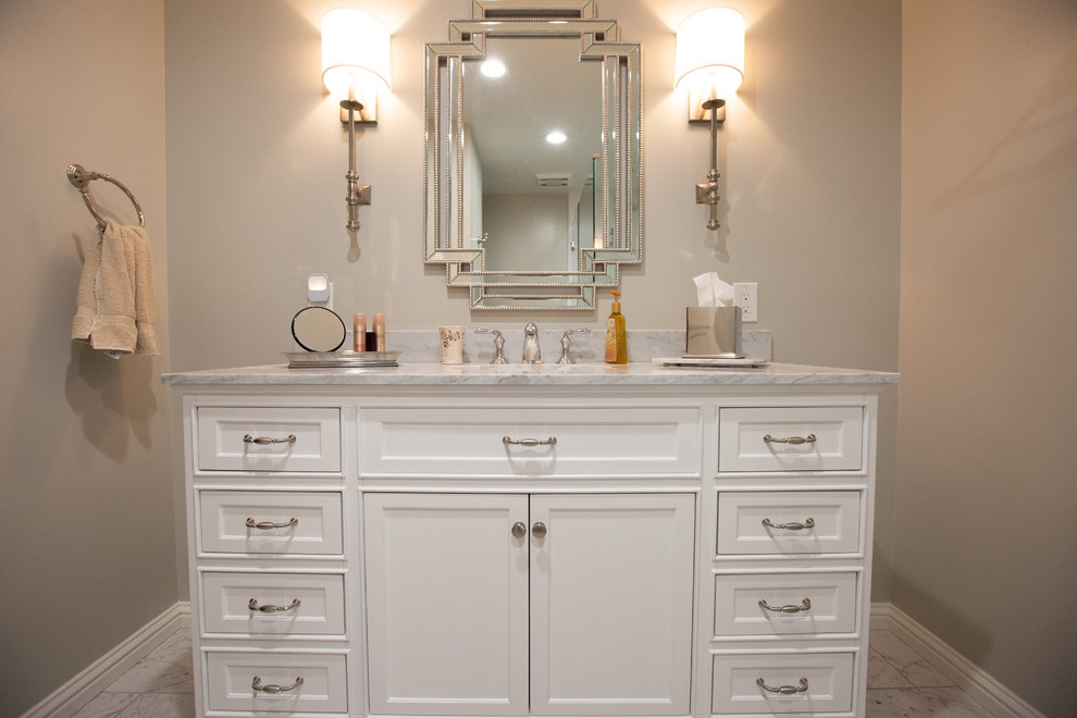 Mid-sized traditional 3/4 bathroom in Sacramento with white cabinets, a corner shower, white tile, porcelain floors, an undermount sink, marble benchtops, white floor, a hinged shower door, white benchtops, recessed-panel cabinets, subway tile and grey walls.