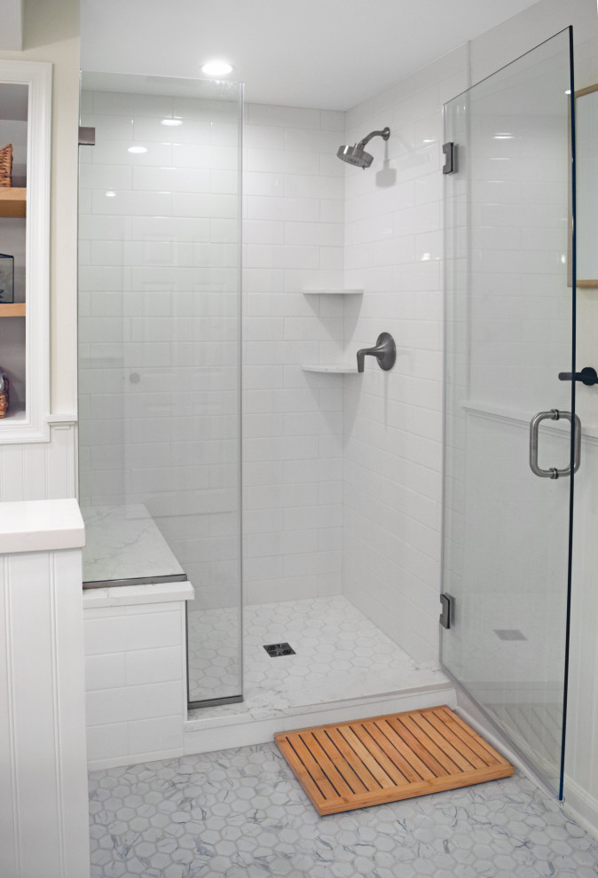 Inredning av ett klassiskt mellanstort vit vitt badrum, med skåp i ljust trä, vit kakel, porslinskakel, klinkergolv i porslin, bänkskiva i kvarts, grått golv och dusch med gångjärnsdörr