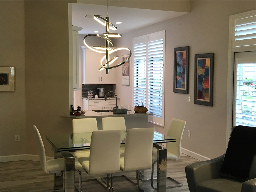 This is an example of a mid-sized contemporary open plan dining in Orlando with grey walls, light hardwood floors and no fireplace.