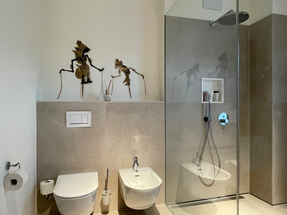 Badezimmer With flächenbündigen Schrankfronten, weißen Schränken, Einbaubadewanne, bodengleicher Dusche, Wandtoilette, beigen Fliesen, Keramikfliesen, weißer Wandfarbe, Keramikboden, Aufsatzwaschbecken, beigem Boden, offener Dusche and Doppelwaschbecken in Cologne