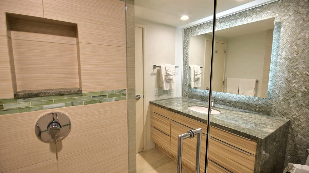 This is an example of a mid-sized transitional 3/4 bathroom in Hawaii with flat-panel cabinets, medium wood cabinets, an alcove shower, green tile, porcelain tile, porcelain floors, an undermount sink and granite benchtops.