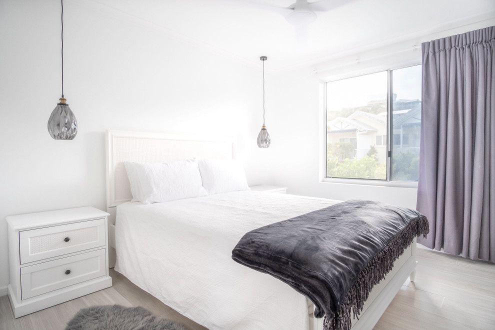 Foto di una piccola camera matrimoniale stile marinaro con pareti bianche, pavimento in laminato e pavimento grigio