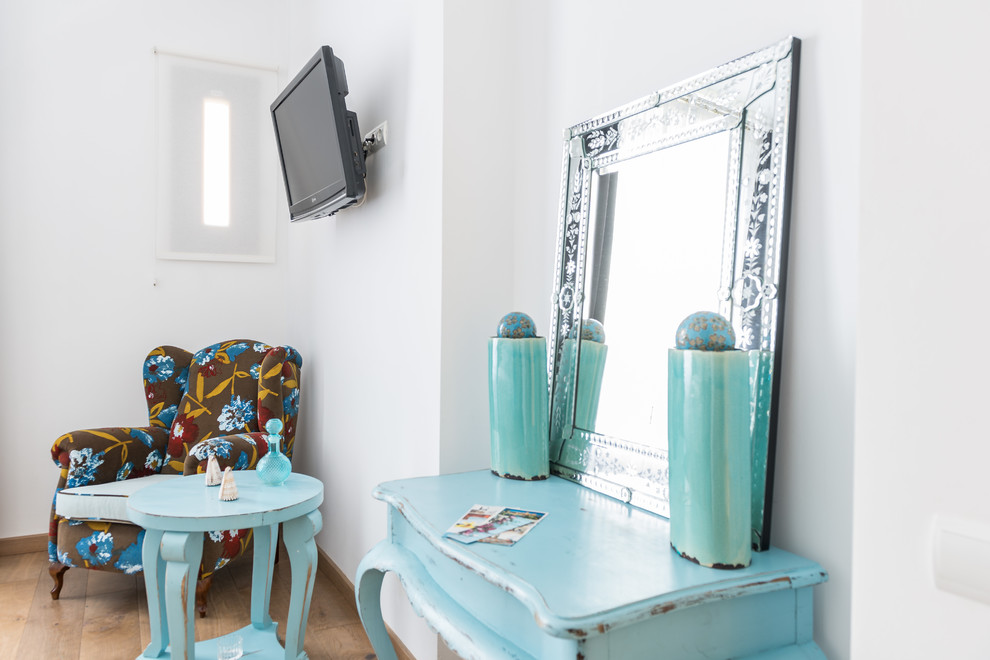 Modelo de dormitorio principal clásico renovado de tamaño medio sin chimenea con paredes blancas y suelo de madera en tonos medios