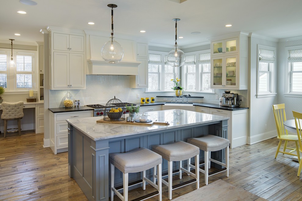 Large country l-shaped eat-in kitchen in Minneapolis with a farmhouse sink, white cabinets, white splashback, medium hardwood floors, with island, recessed-panel cabinets, marble benchtops, ceramic splashback and panelled appliances.