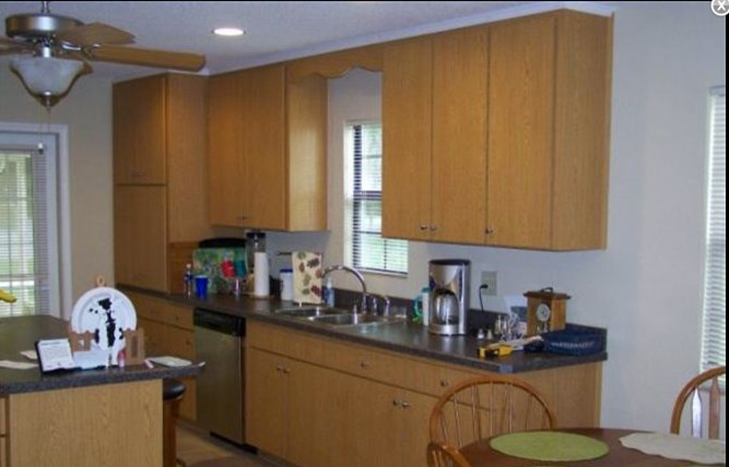 Eat-in kitchen - mid-sized traditional l-shaped light wood floor eat-in kitchen idea in Charlotte with a drop-in sink, flat-panel cabinets, brown cabinets, laminate countertops, stainless steel appliances and no island