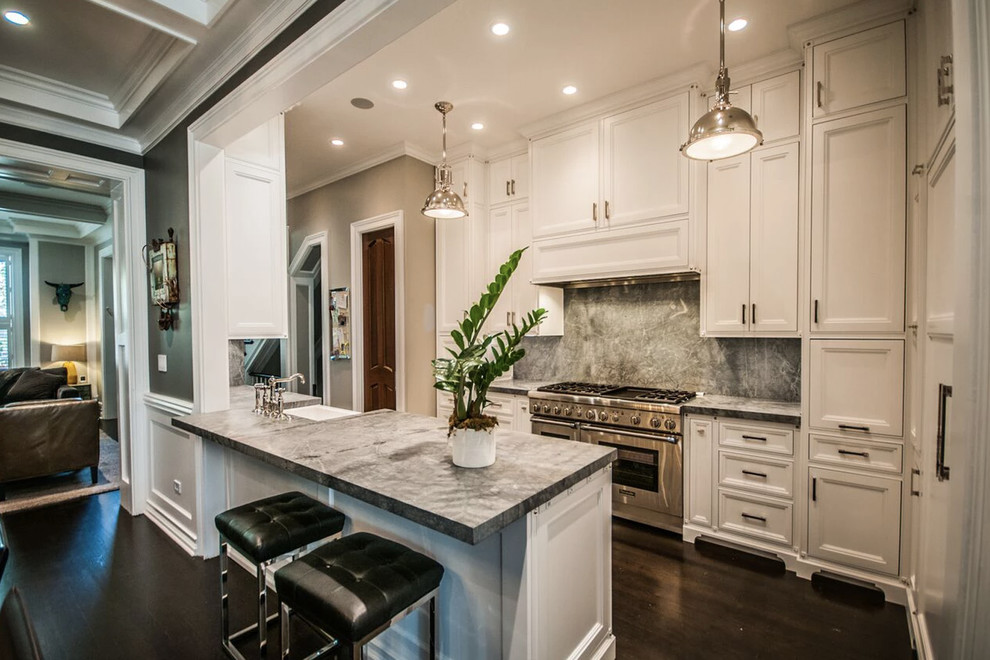 Small traditional galley eat-in kitchen in Chicago with a farmhouse sink, flat-panel cabinets, white cabinets, quartzite benchtops, grey splashback, stone slab splashback, stainless steel appliances, medium hardwood floors, a peninsula, brown floor and grey benchtop.