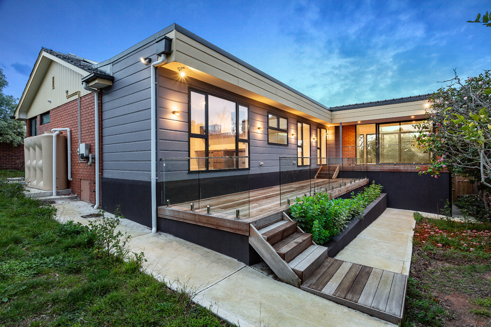 This is an example of a mid-sized contemporary two-storey grey house exterior in Melbourne with mixed siding, a flat roof and a metal roof.