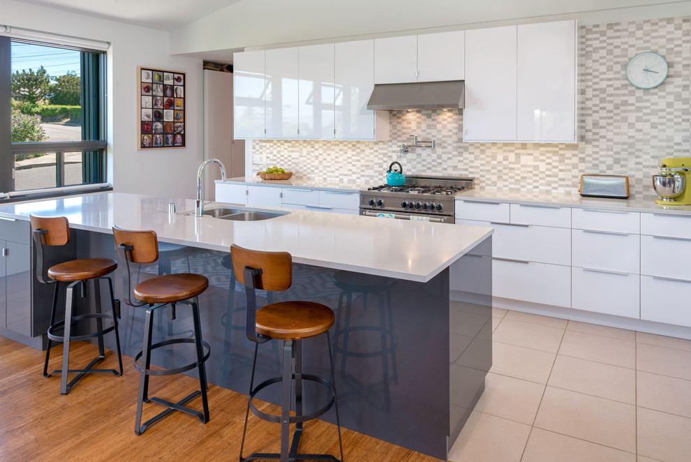 Photo of a modern kitchen in San Francisco with a double-bowl sink, white cabinets, quartzite benchtops, white splashback, ceramic splashback, stainless steel appliances, porcelain floors and with island.