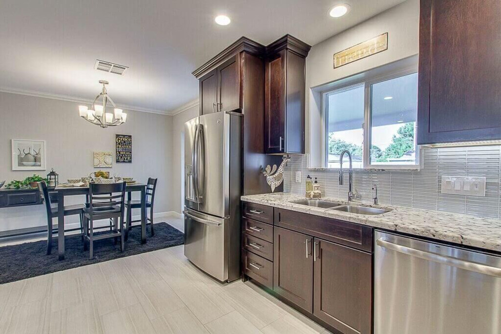 Mid-sized transitional u-shaped dark wood floor eat-in kitchen photo in Phoenix with a double-bowl sink, raised-panel cabinets, dark wood cabinets, wood countertops, white backsplash, subway tile backsplash, white appliances and no island