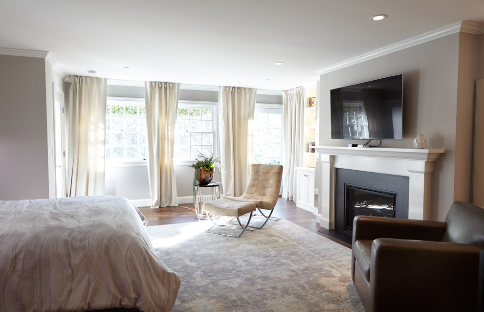 Large transitional master bedroom in San Francisco with beige walls, medium hardwood floors, a standard fireplace and a wood fireplace surround.