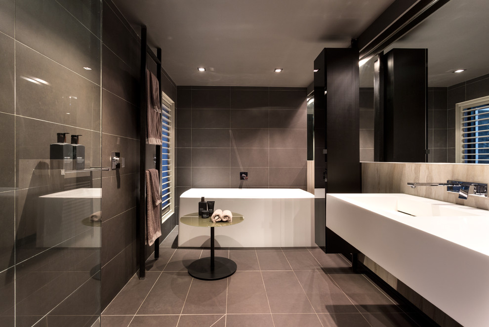 Inspiration for a large contemporary master bathroom in Melbourne with black cabinets, a freestanding tub, an open shower, gray tile, ceramic tile, multi-coloured walls, ceramic floors, an integrated sink and an open shower.