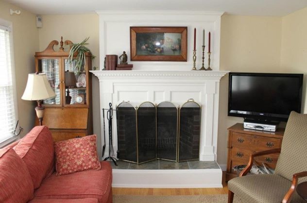 Inspiration for a small traditional open concept living room in Portland Maine with a standard fireplace and a wood fireplace surround.