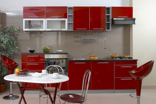 Small modern single-wall eat-in kitchen in Columbus with no island, flat-panel cabinets, red cabinets, quartz benchtops, beige splashback, porcelain splashback, stainless steel appliances, an undermount sink and porcelain floors.