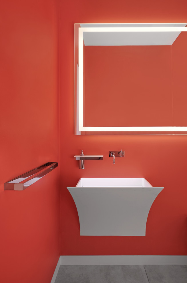 Photo of a contemporary powder room in San Francisco with orange walls, a wall-mount sink and grey floor.