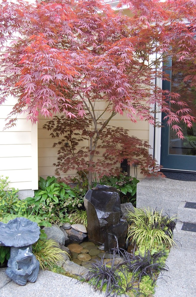 This is an example of a small arts and crafts courtyard partial sun garden in Seattle with a water feature.