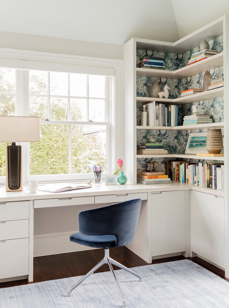 Inspiration for a mid-sized transitional home office in Boston with white walls, a built-in desk, a library and dark hardwood floors.