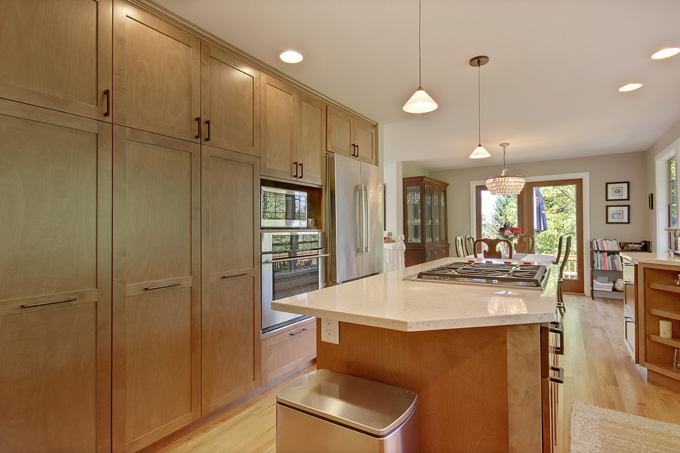 Open concept kitchen - mid-sized contemporary galley light wood floor open concept kitchen idea in Seattle with an undermount sink, shaker cabinets, medium tone wood cabinets, quartz countertops, stainless steel appliances and an island