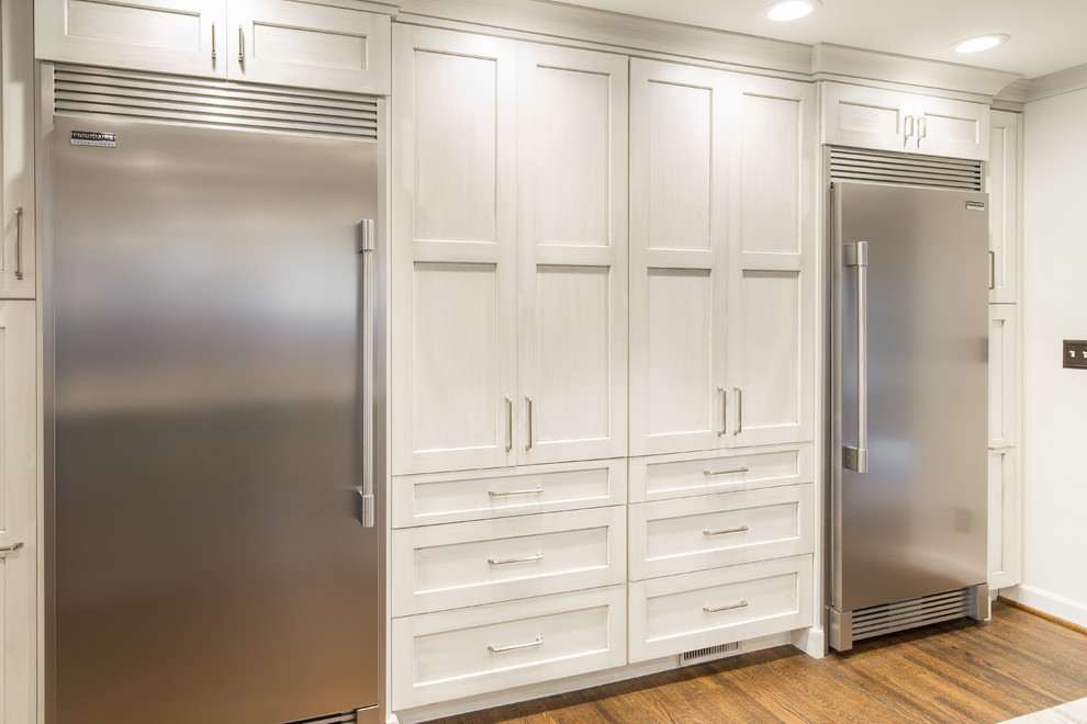 Inspiration for a large transitional single-wall medium tone wood floor and brown floor eat-in kitchen remodel with an undermount sink, shaker cabinets, white cabinets, marble countertops, multicolored backsplash, matchstick tile backsplash, stainless steel appliances and two islands