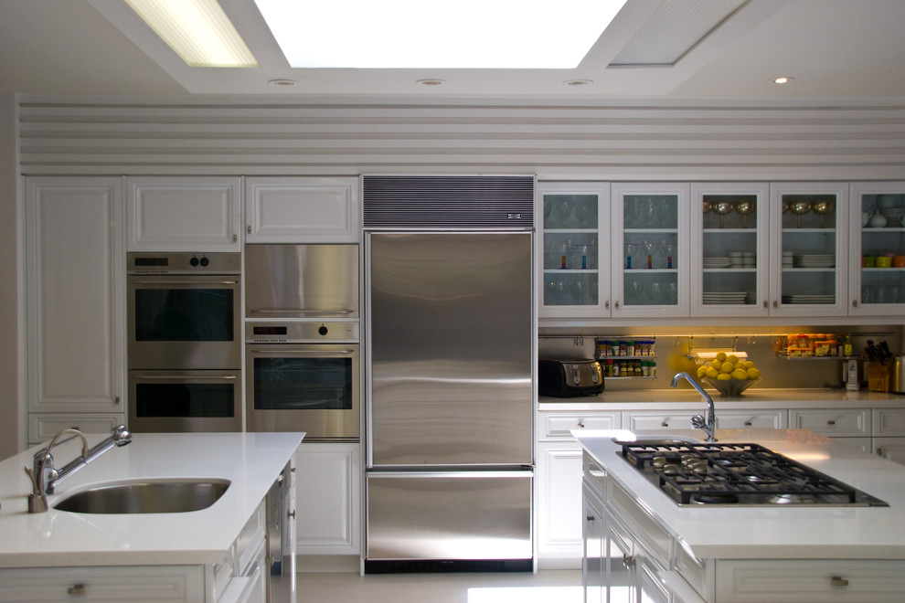 Example of a large transitional u-shaped marble floor eat-in kitchen design in Toronto with a single-bowl sink, raised-panel cabinets, white cabinets, solid surface countertops, stainless steel appliances and a peninsula
