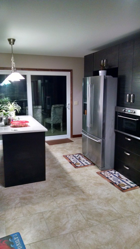 Example of a mid-sized transitional ceramic tile enclosed kitchen design in Providence with flat-panel cabinets, black cabinets, stainless steel appliances and an island