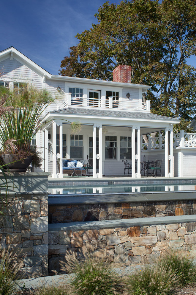 Photo of a mid-sized beach style one-storey grey house exterior in Providence with wood siding, a gambrel roof and a shingle roof.