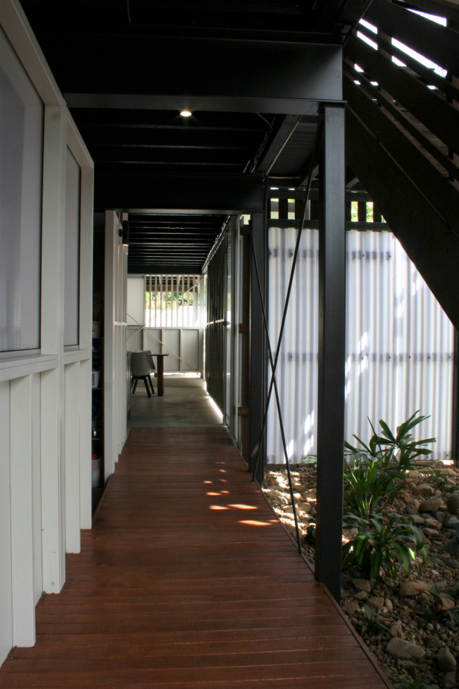 Mid-sized modern hallway in Brisbane with white walls, medium hardwood floors, brown floor, exposed beam and panelled walls.