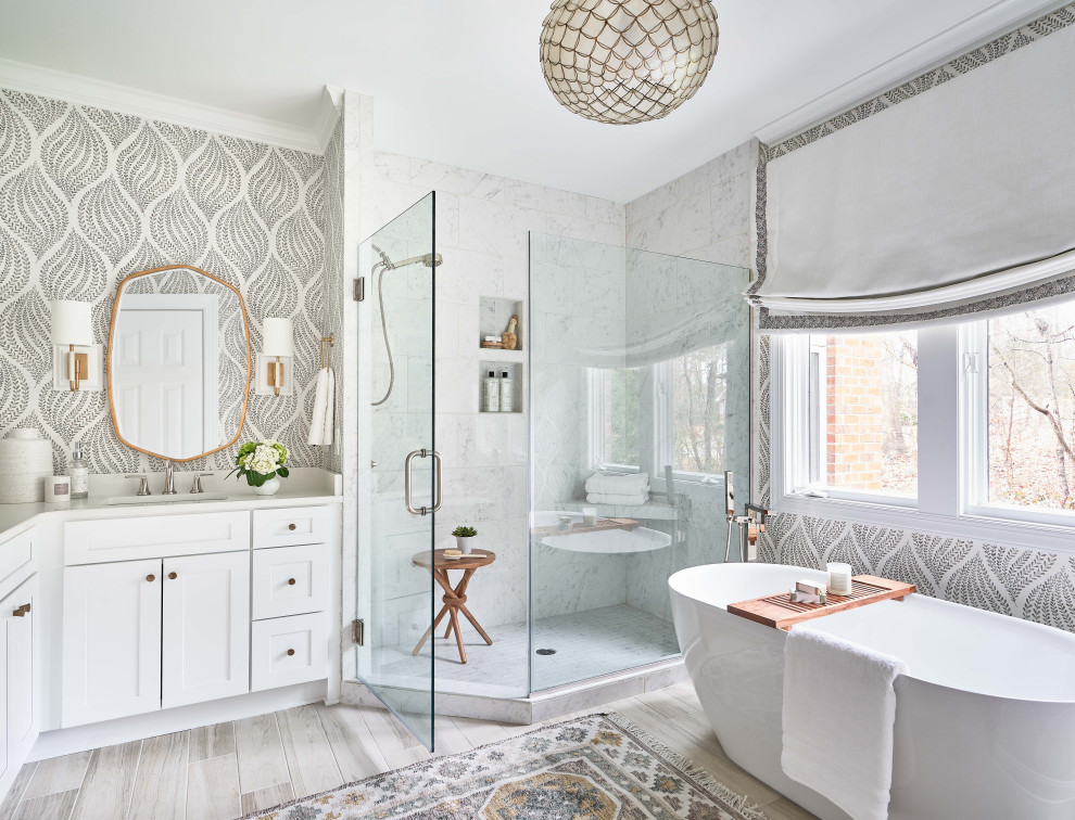 Example of a transitional master single-sink, wallpaper, wood-look tile floor and beige floor bathroom design in Other with white cabinets, white countertops, shaker cabinets, multicolored walls, a hinged shower door and a built-in vanity
