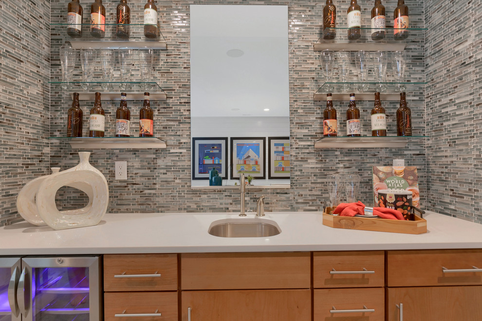 Photo of a contemporary single-wall wet bar in Denver with an undermount sink, flat-panel cabinets, medium wood cabinets, quartz benchtops, multi-coloured splashback, glass sheet splashback, carpet, beige floor and beige benchtop.