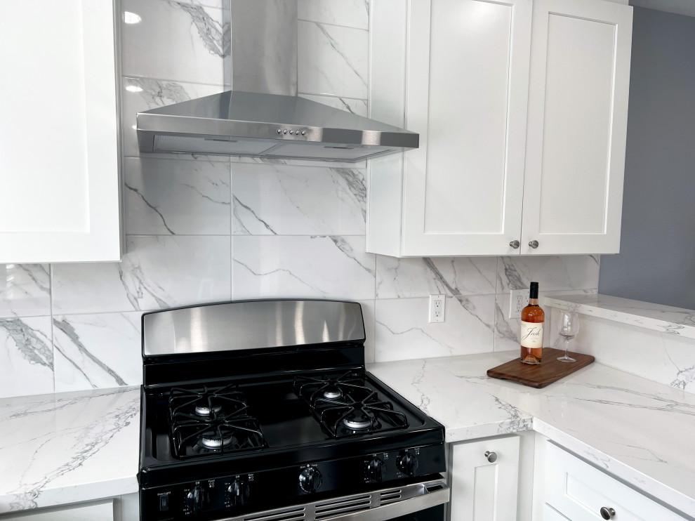 Exempel på ett mellanstort modernt vit vitt kök, med en dubbel diskho, skåp i shakerstil, vita skåp, bänkskiva i rostfritt stål, vitt stänkskydd, stänkskydd i marmor, rostfria vitvaror, laminatgolv, en halv köksö och grått golv
