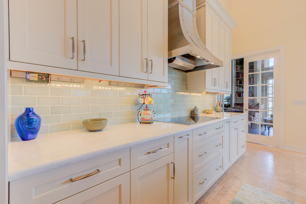 Enclosed kitchen - large transitional single-wall enclosed kitchen idea with an undermount sink, flat-panel cabinets, white cabinets, quartz countertops, blue backsplash, stone tile backsplash, stainless steel appliances and an island