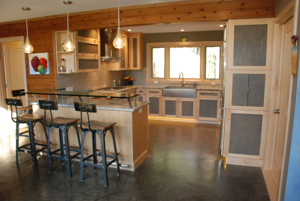 Photo of a mid-sized contemporary u-shaped open plan kitchen in Indianapolis with a farmhouse sink, recessed-panel cabinets, grey cabinets, quartzite benchtops, grey splashback, porcelain splashback, stainless steel appliances, concrete floors and a peninsula.