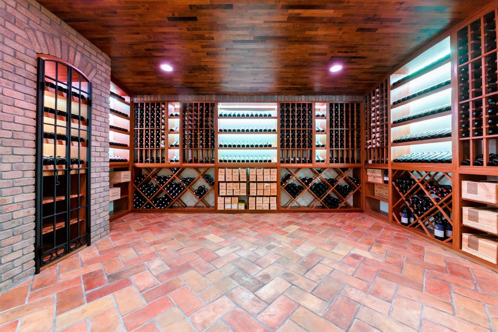 This is an example of an expansive traditional wine cellar in New York with terra-cotta floors and storage racks.