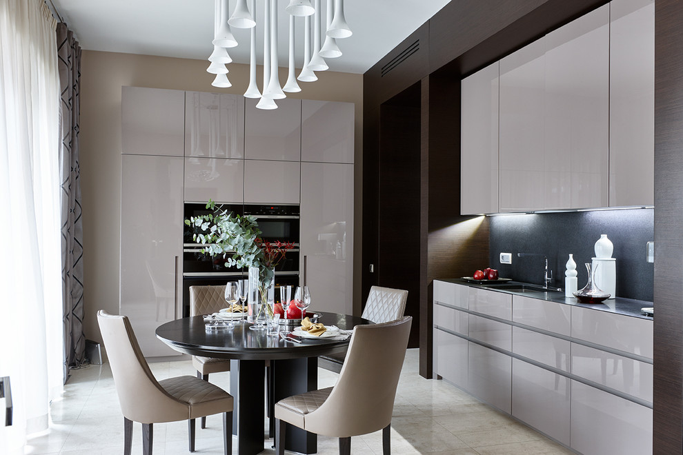 Design ideas for a contemporary eat-in kitchen in Moscow with an undermount sink, flat-panel cabinets, beige cabinets, granite benchtops, black splashback, black appliances, travertine floors, beige floor and no island.