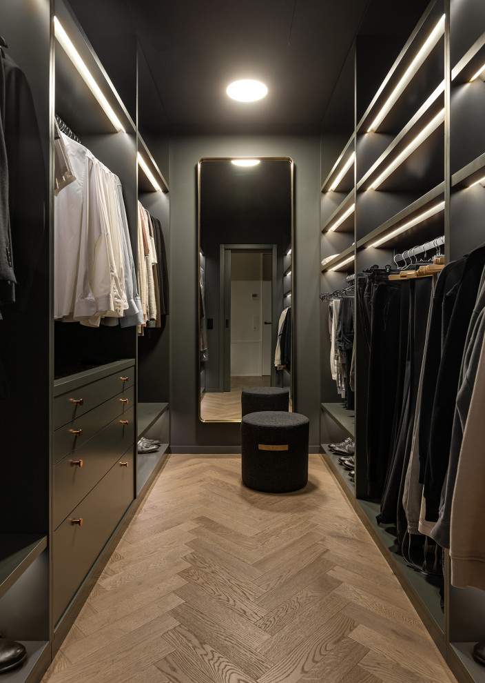 Bild på ett mellanstort funkis walk-in-closet för män, med öppna hyllor, grå skåp och mellanmörkt trägolv