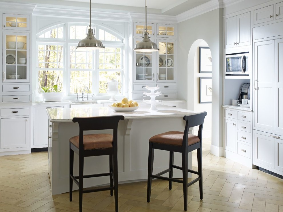 Inspiration for a mid-sized transitional u-shaped eat-in kitchen in Bridgeport with an undermount sink, shaker cabinets, white cabinets, quartzite benchtops, panelled appliances, limestone floors and with island.