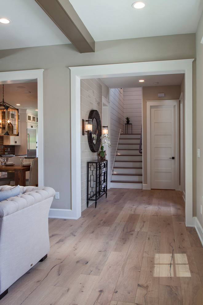 Inspiration for a mid-sized transitional light wood floor foyer remodel in Orlando with beige walls and a black front door