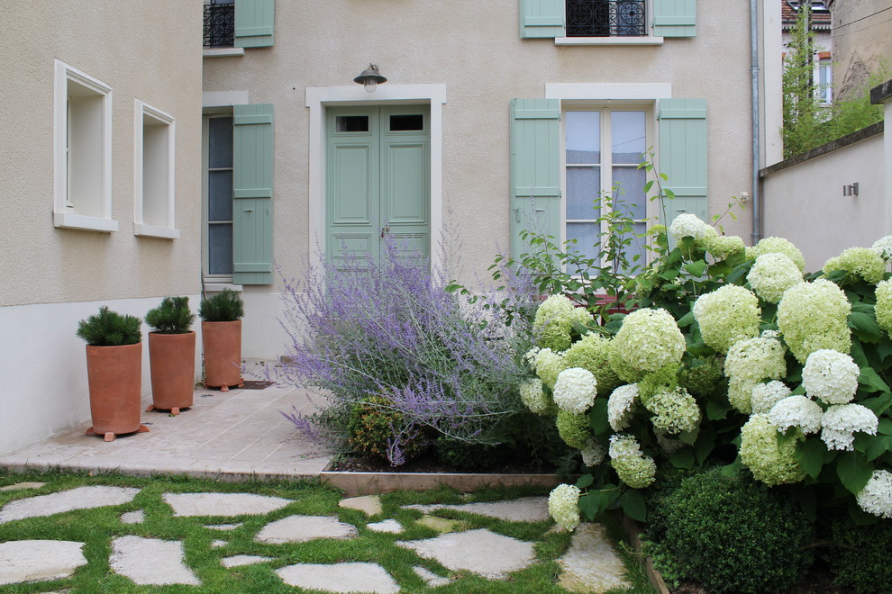 Mid-sized traditional front yard partial sun garden in Reims with natural stone pavers.