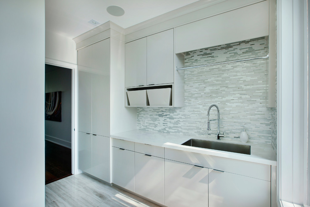 Design ideas for a large modern galley dedicated laundry room in Toronto with an undermount sink, flat-panel cabinets and quartz benchtops.