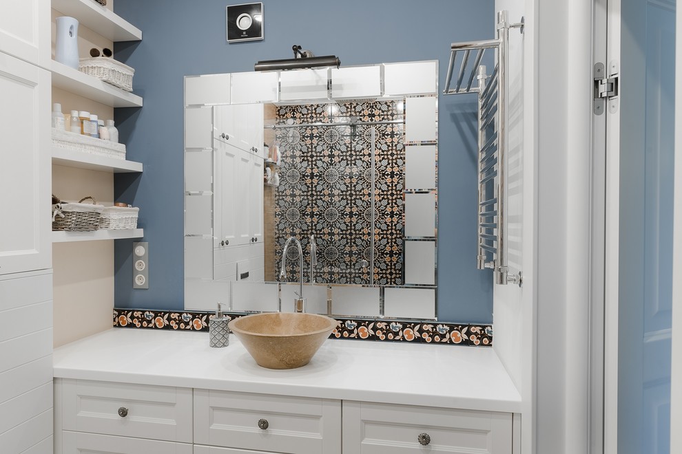 This is an example of a contemporary bathroom in Other with white cabinets, blue walls and a vessel sink.