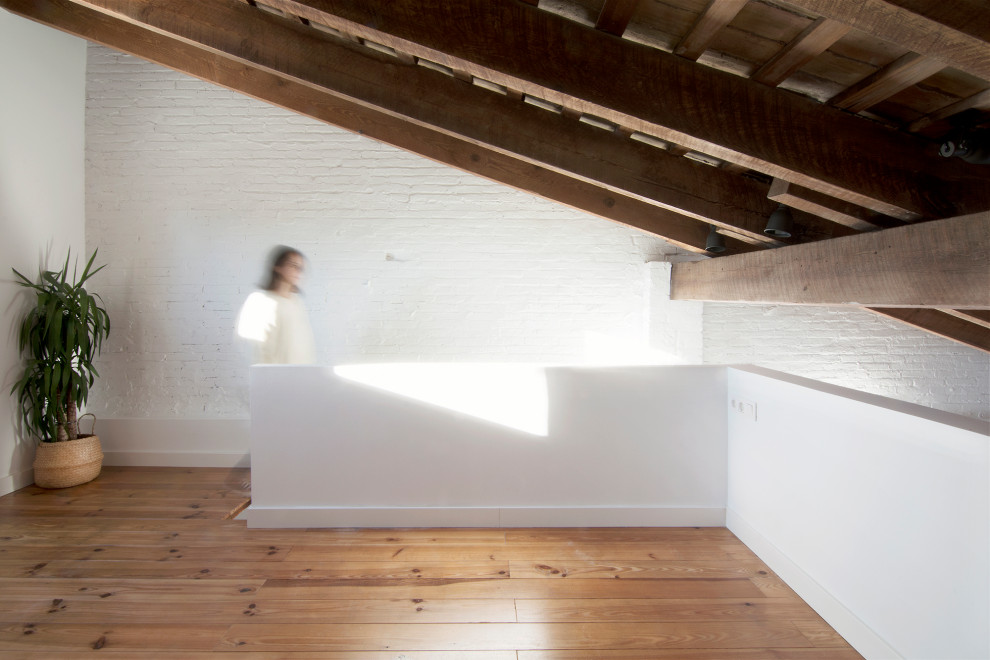 Idee per una piccola camera da letto stile rurale con pavimento in legno massello medio, travi a vista e pareti in mattoni