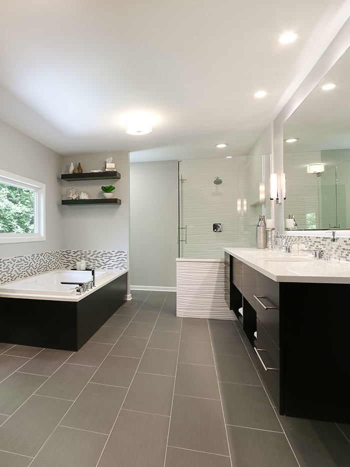Large contemporary master bathroom in Chicago with flat-panel cabinets, dark wood cabinets, a drop-in tub, an open shower, a one-piece toilet, multi-coloured tile, glass tile, beige walls, porcelain floors, an undermount sink and engineered quartz benchtops.