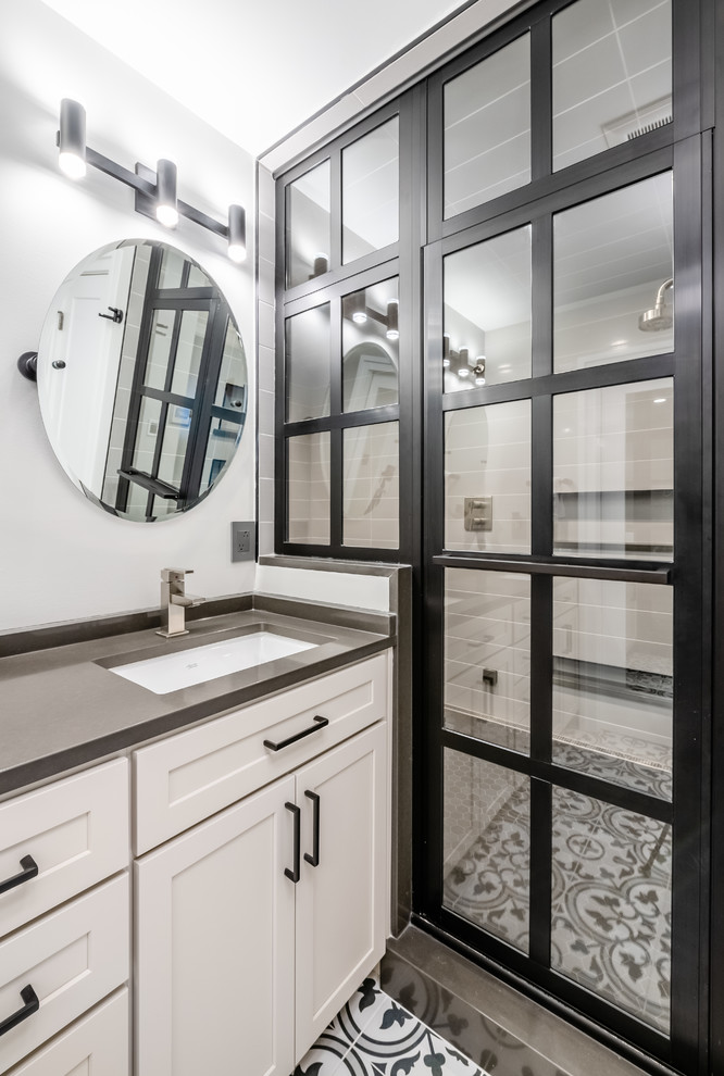 This is an example of a mid-sized contemporary bathroom in DC Metro with shaker cabinets, grey cabinets, an alcove shower, grey walls, ceramic floors, an undermount sink, engineered quartz benchtops, multi-coloured floor, a hinged shower door and grey benchtops.
