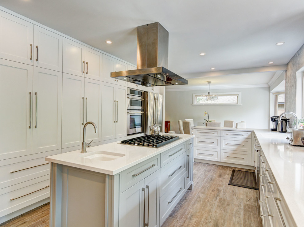 This is an example of a large contemporary l-shaped eat-in kitchen in Vancouver with an undermount sink, shaker cabinets, white cabinets, granite benchtops, grey splashback, stone tile splashback, stainless steel appliances, porcelain floors and with island.
