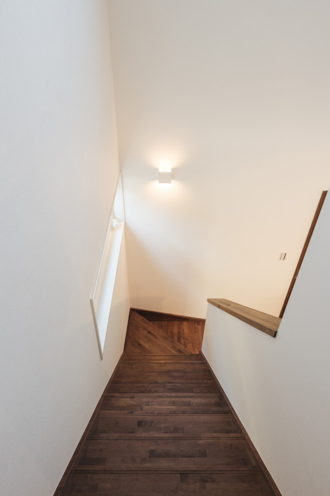 Ejemplo de escalera en L de tamaño medio con escalones de madera pintada, contrahuellas de madera pintada, barandilla de madera y papel pintado