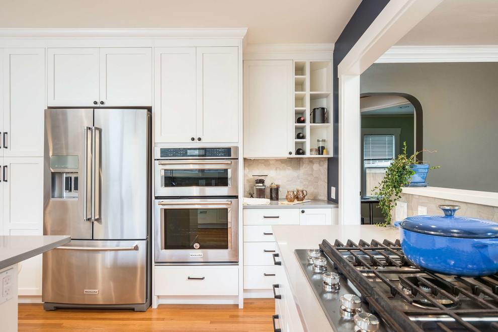 This is an example of a modern kitchen in Seattle with flat-panel cabinets and white cabinets.