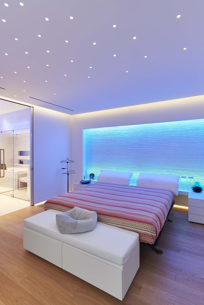Esempio di una camera matrimoniale minimalista con pareti bianche, parquet chiaro e pavimento beige